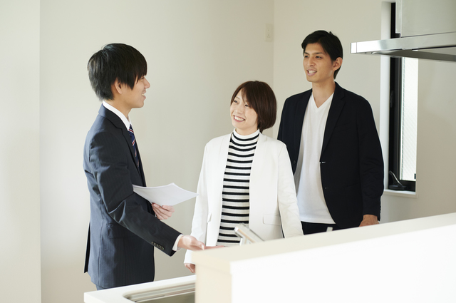 スマートフォンで物件情報を眺めて悩む人